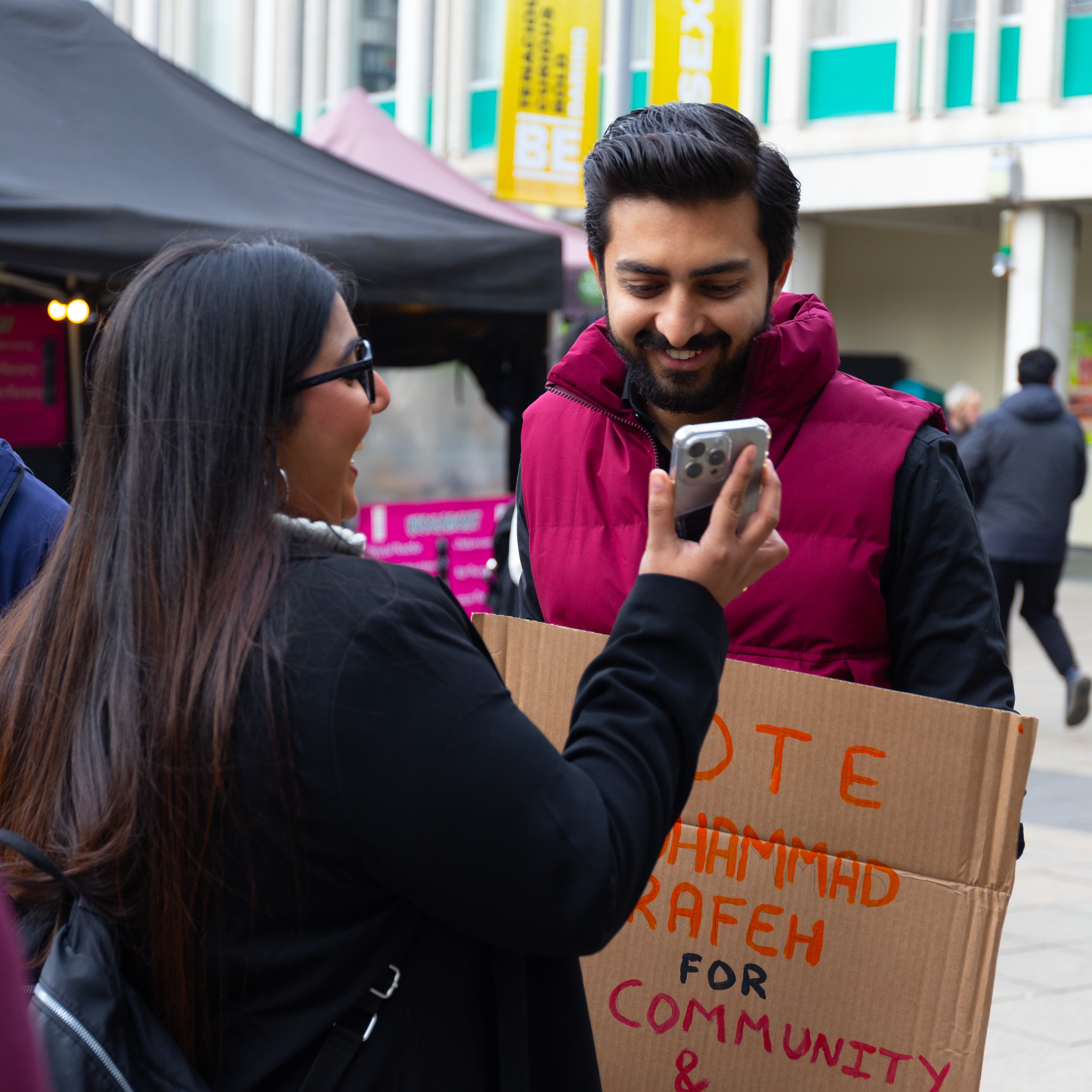 Two essex students laughing at a phone